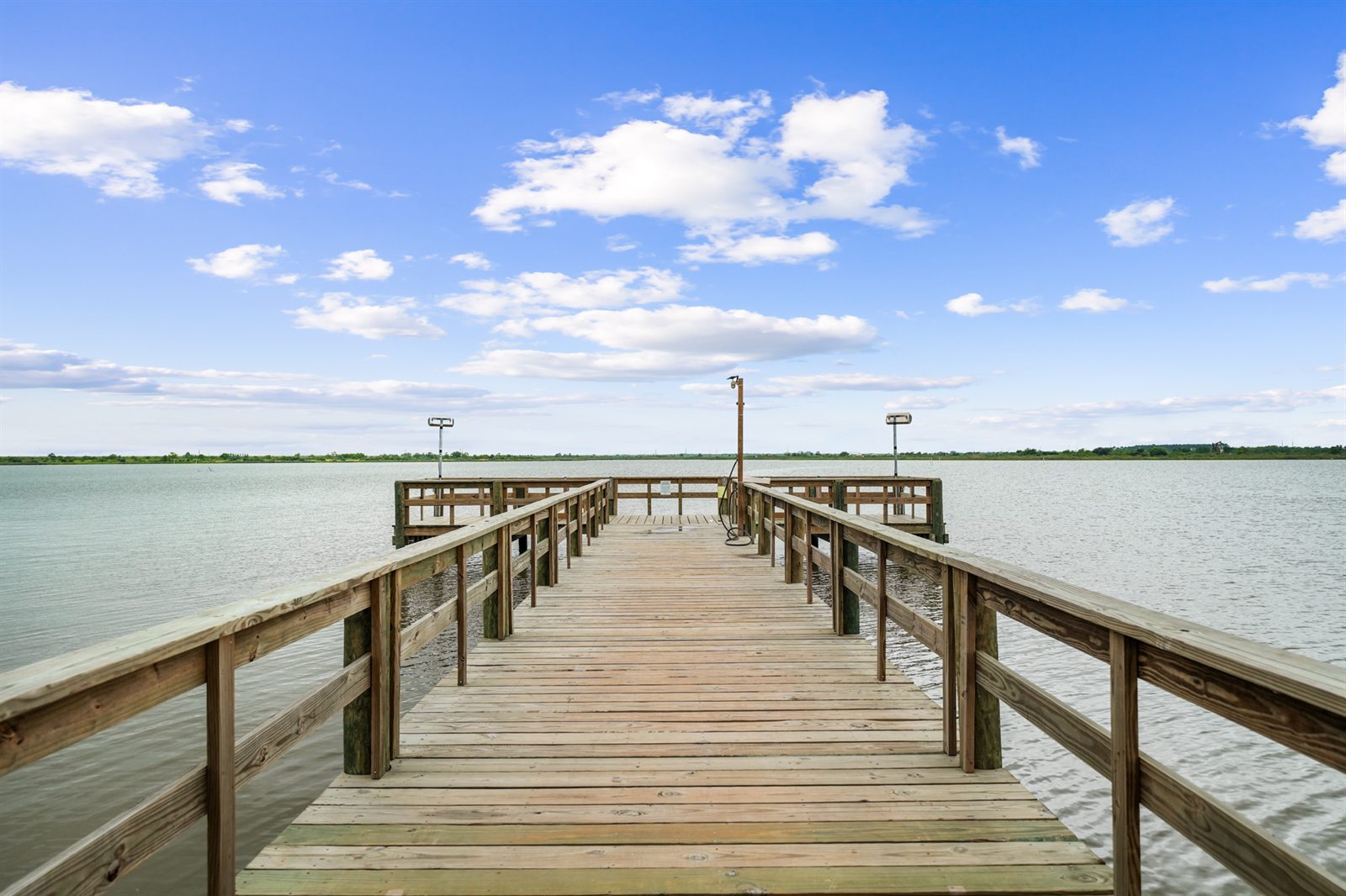 Lighted fishing pier boardwalk extending over Dickinson Bayou (resort guests only)